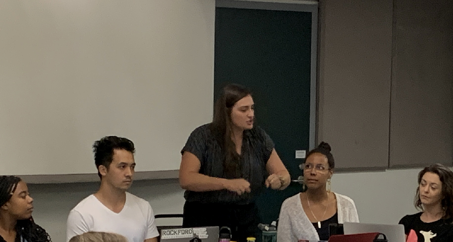 A graduate director gives notes to a cast of actors.